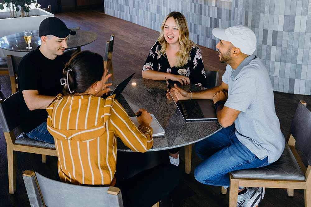 derek-coleman-unsplash-a-group-of-people-sitting-around-a-table